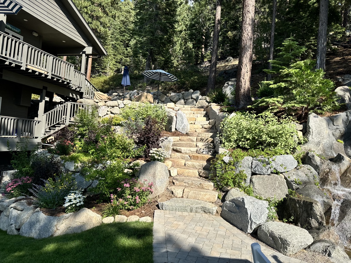 Complete Tahoe landscape design with stone stairs, boulders, lawn, planting beds, and water feature
